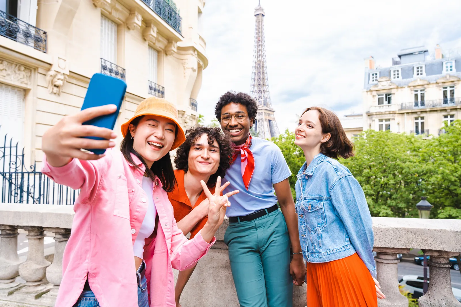 A group of friends taking a selfie in front of the Eiffel Tower