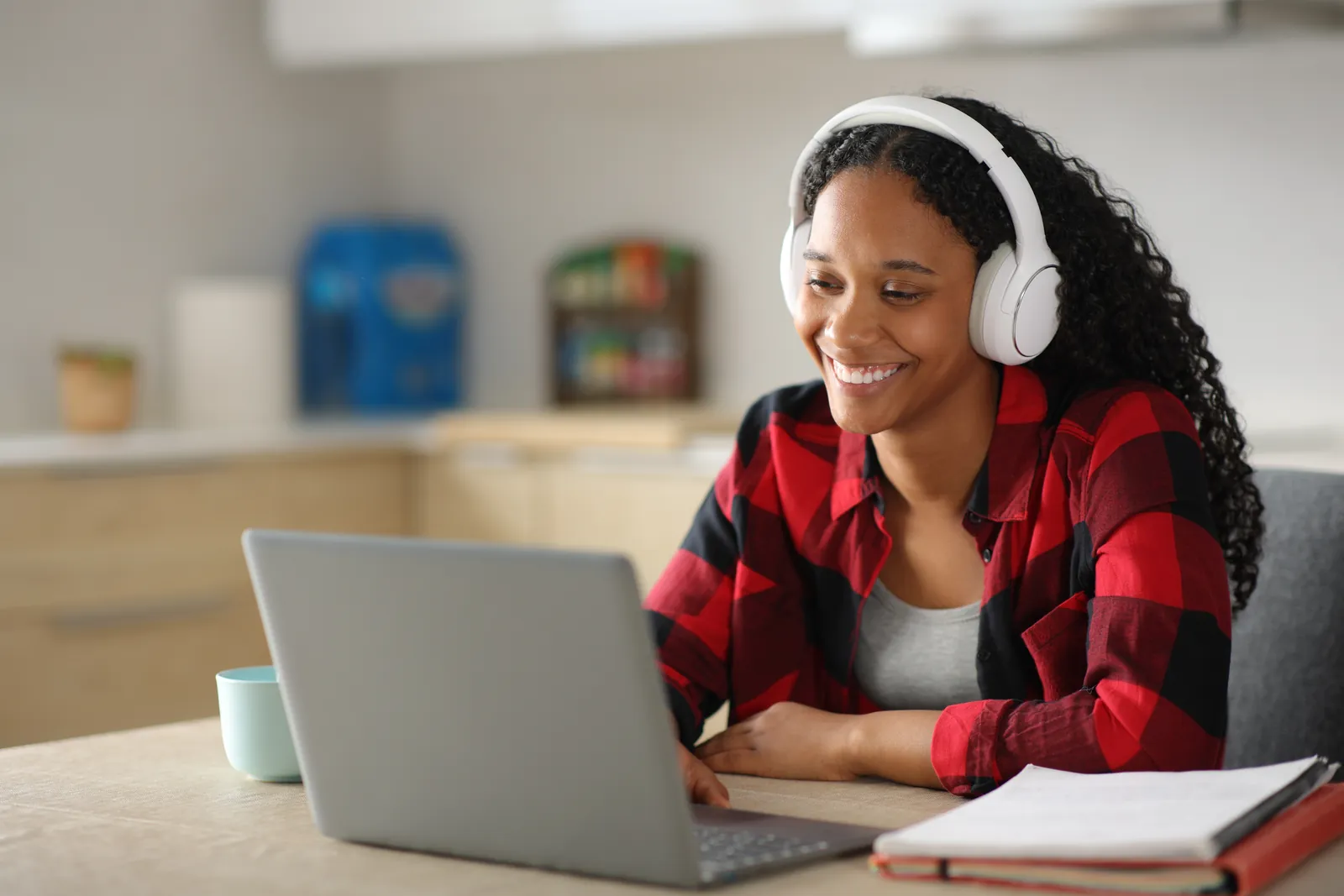 Une femme au casque audio souriant pendant un cours en ligne